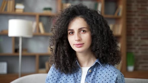 Calm Woman with Curly Hair Looking at Camera