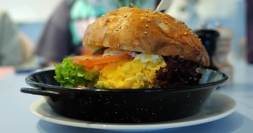 Artisanal Burger with Layers of Creamy Scrambled Eggs Lettuce and Tomato
