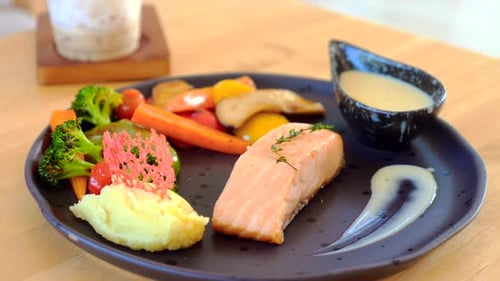 Salmon fillet with vegetables on plate close up