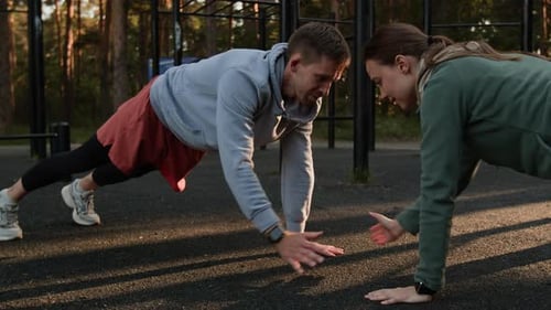 Couple doing Pushups at Outdoor Gym