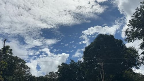 Bewegung weißer Wolken gegen den blauen Himmel in einem Dorf. Zeitraffer