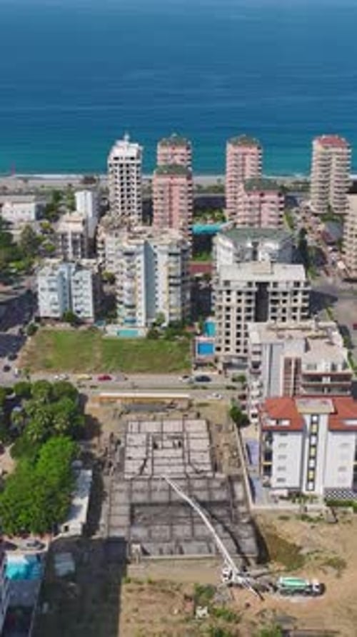 Vertical Video Modern Buildings in the Final Phase of Construction with Workers Completing the Last