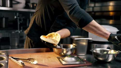 Closeup of a Chef in Black Gloves Putting Pies Tomato Bun with a Spoon