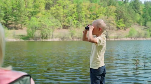Boy With Binoculars Looking at Lake