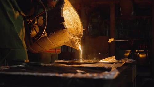 Foundry Worker Pouring Liquid Metal Into Molds