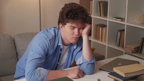 Young Adult Dozes at Table at Home