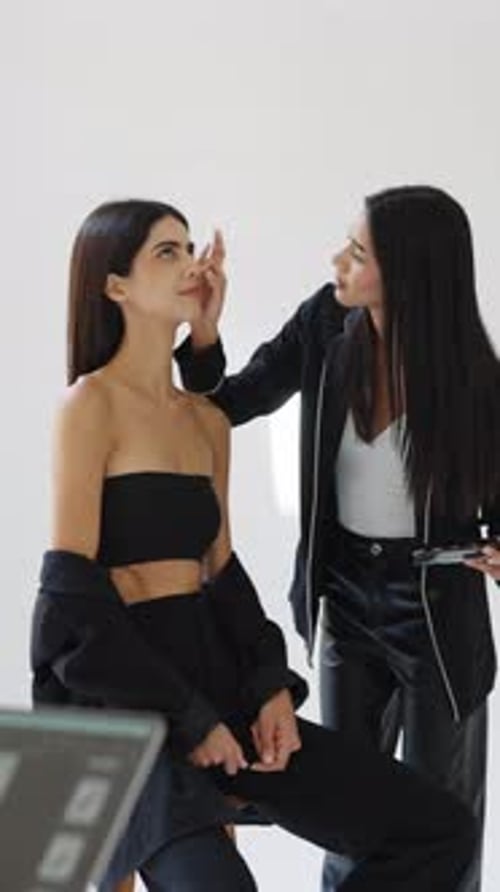 Makeup Artist Applying Makeup to Fashion Model in Studio