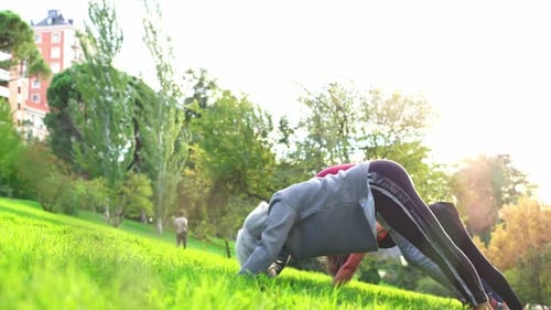 Three Women of Different Ages Practicing Yoga Outdoors in a Park