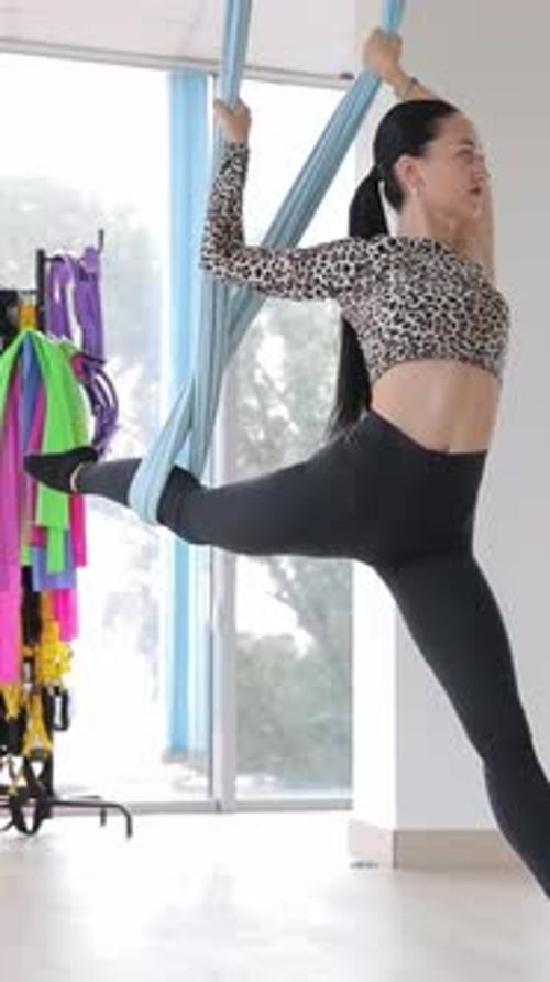 Woman Doing Aerial Yoga in Fitness Studio