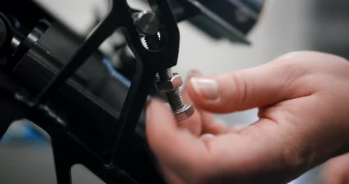 Close up of hands unscrewing a nut while repairing an engine