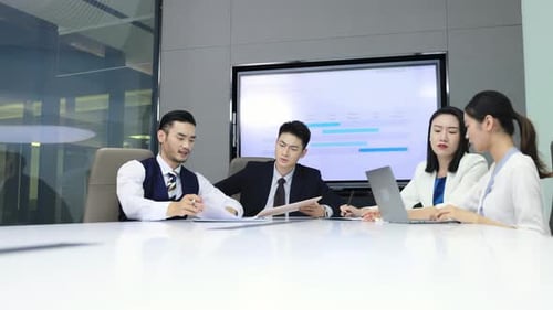 Groupe de collègues tenant une réunion de travail dans la salle de conférence, assis autour de la table de bureau, écoutez-moi