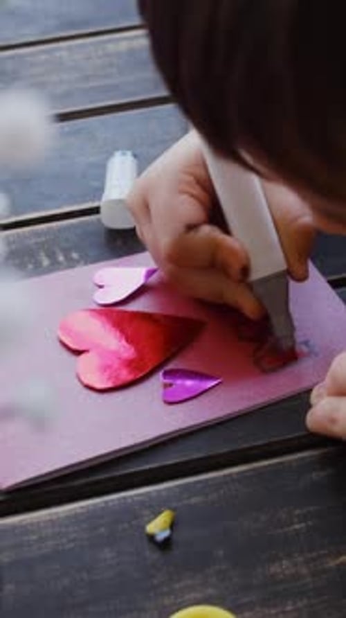 Child Crafting a Heart Card at Table