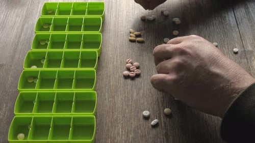 Organizing Medication into Pill Organizer on Table