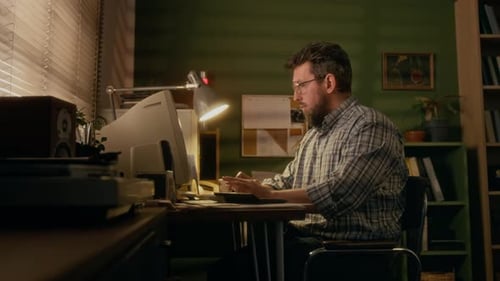 Man Works at Retro Computer at Night