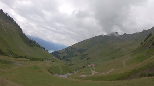 Serene alpine valley with view on Brienz lake, Switzerland on misty summer day