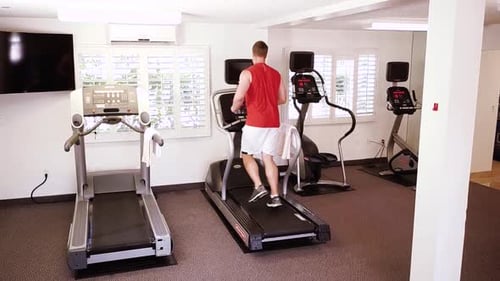A small view of big sport room where two people are having workout. They are running on elliptical T