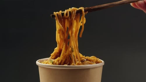 Asian Fast Food Noodles with Soy Meat Parsley Closeup Dropping Chopsticks in Noodles Soup Instant