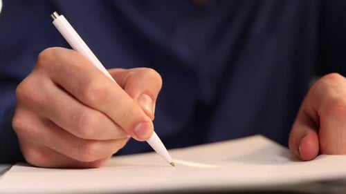 Close-up Hand Writes on Paper with Pen