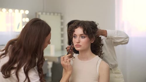 Woman Getting Makeup and Hair Done Professionally