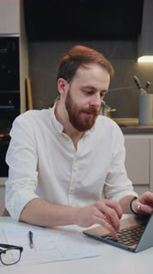 Attractive Relaxed Adult Man Sitting in Kitchen on Desk and Meditating with Closed Eyes When Doing