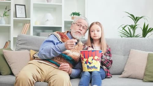Cute Child with Grandpa Watching Cartoon End Eating Popcorn