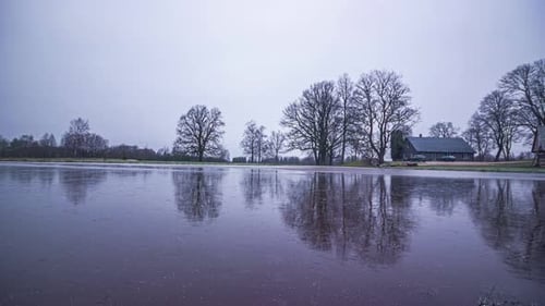 The four seasons pass over a house next to a lake in a time lapse shot.