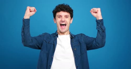 Man Celebrates Success Against a Blue Background