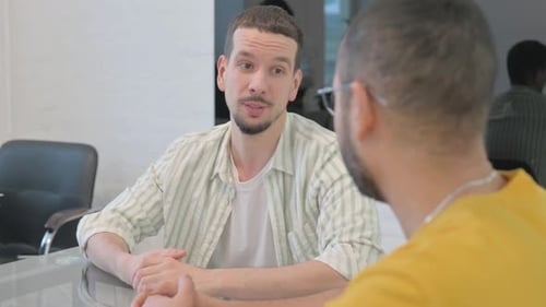 Close up of Young Man Talking with Colleague