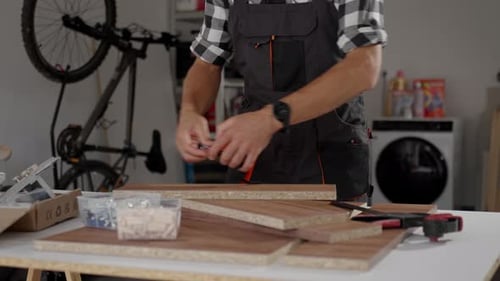 Man Assembling Wooden Furniture Measuring Board with Tape Measure