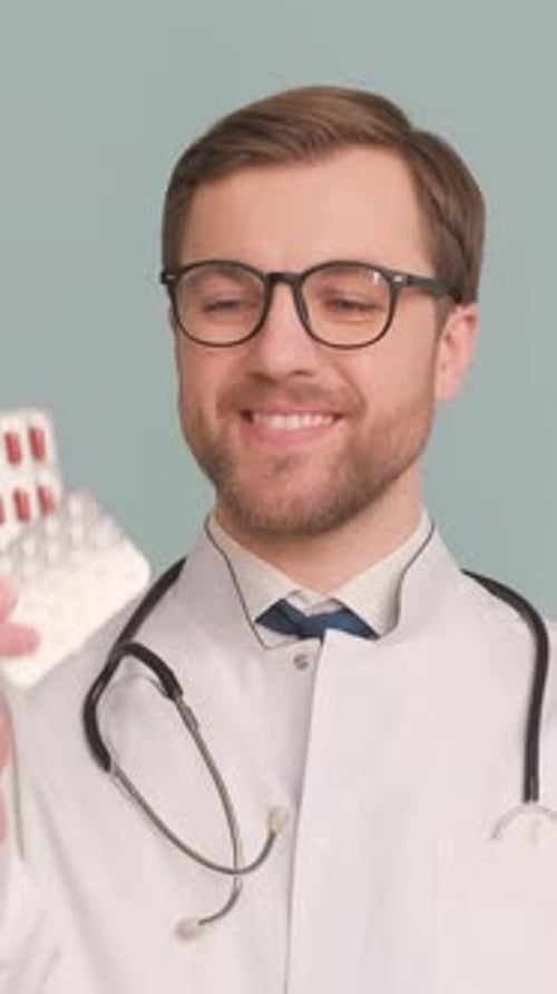 Male Doctor Shows Pills and Throws Them Away Isolated on Gray Background in Studio Vertical Video