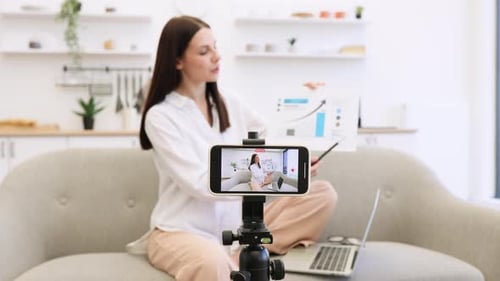 Junge kaukasische brünette Finanzierin filmt sich selbst auf dem Handy