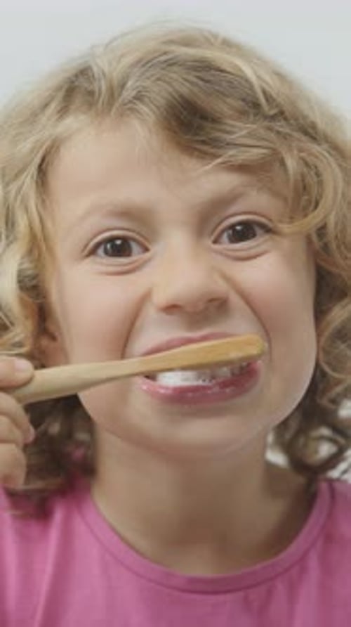 Small Girl Brushing Her Teeth in Vertical