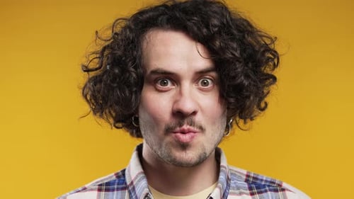 Surprised Young Adult Man on Yellow Background