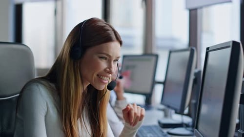 Nahaufnahme des Arbeitscomputers eines lächelnden Servicebetreibers. Beratungskunde für freundliche, weibliche Headsets