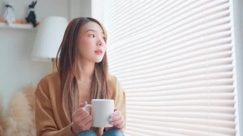 Woman Enjoying Hot Drink by Window