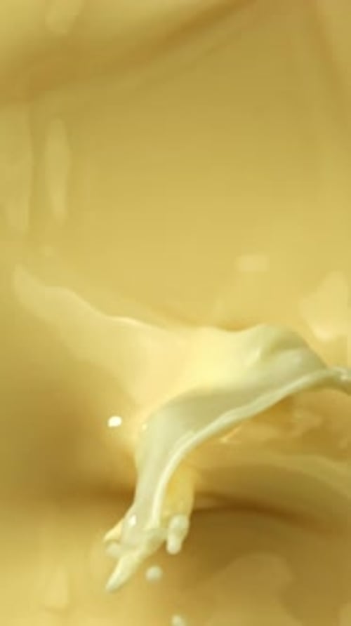 Super Slow Motion Pieces of White Chocolate Fall Into Liquid Chocolate Filmed on a Highspeed Camera