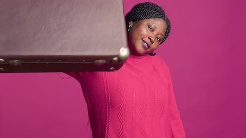 Mulher animada segurando uma mala marrom