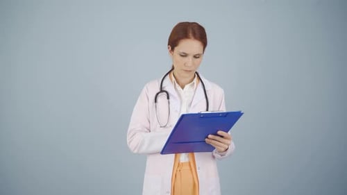 The doctor examining the paperwork is thoughtful.