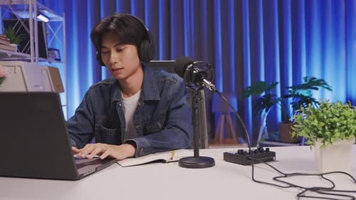 Confident content creator livestreaming and multitasking in modern home studio