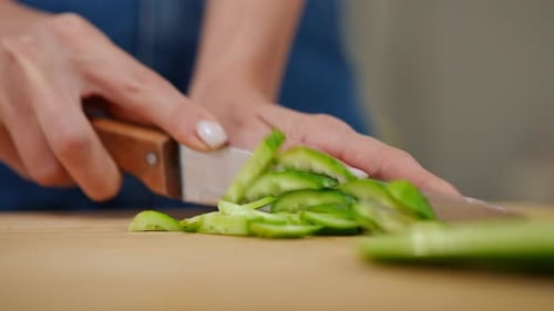 Closeup Female Hand Slicing Green Cucumber with Knife Closeup Unrecognizable Young Caucasian Woman