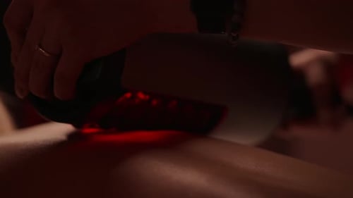 Woman Receiving Massage with Red Light Therapy Device