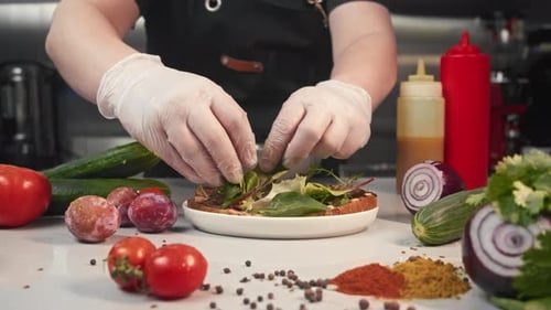 Chef Creates Juicy Delicious Burger with Lettuce Leaves and Vegetables in Restaurant Kitchen