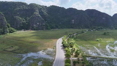 Winding Countryside Road Through Lush Rice Paddies and Dramatic Karst Mountains