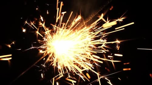 Sparkler Emitting Golden Sparks in Dark Background