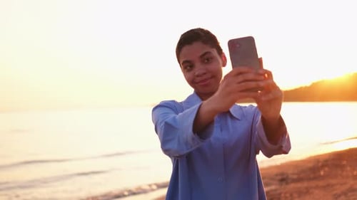 Woman Takes Selfie on Beach at Sunrise