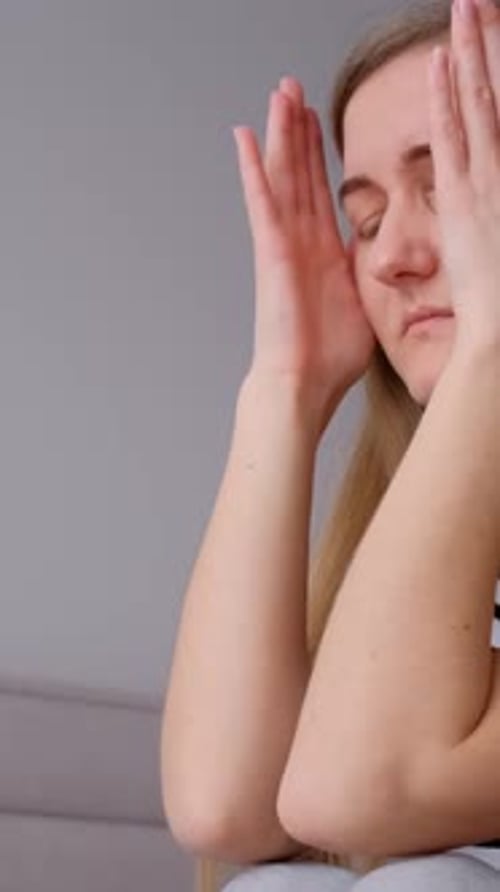 Distressed woman holding her head in her hands