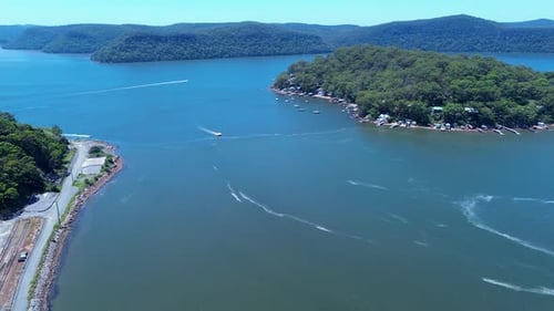 Drone aerial landscape showing fishing boats moving through channel inlet near Dangar Island rural