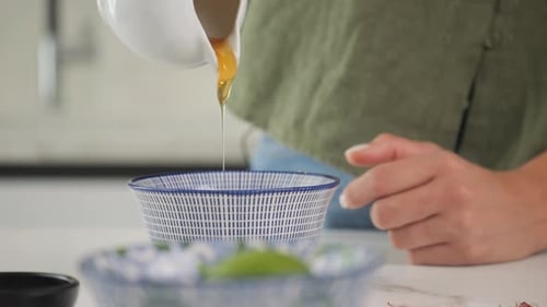 Adding honey to a dish while cooking. Close-up slow motion shot.