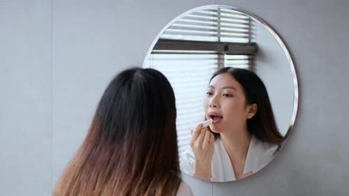 Young Woman Enjoying a Self Care Routine in a Modern Bathroom Setting