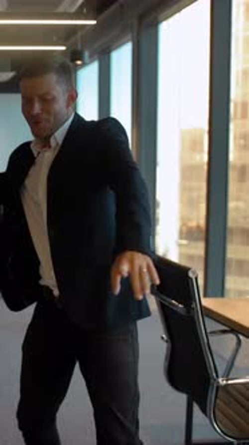 Vertical of Couple in Business Office Dancing After Winning Deal Celebrating